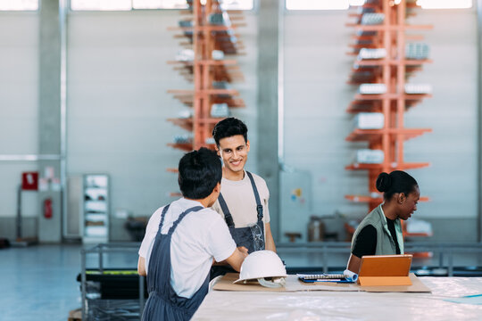 Woman and Two Men Working in Factory 