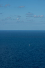 Tiny sailboat on the blue ocean