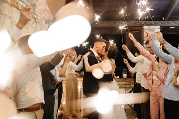 Newlyweds kissing among sparkles