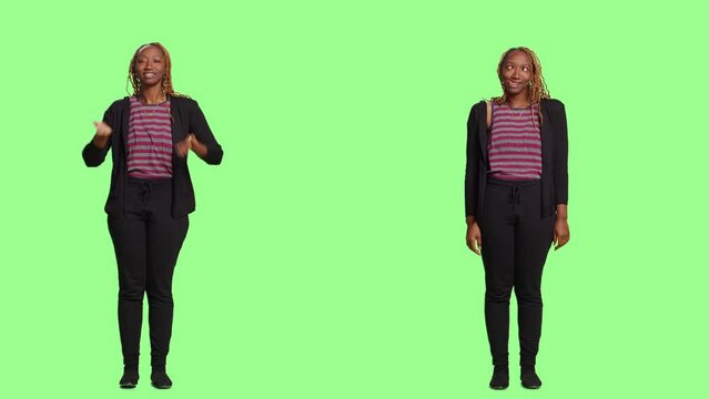 Woman being playful on two sides of full body greenscreen backdrop, blowing air kisses with kissy face and fooling around. Sticking tongue out acting silly and flirty, joyful girl.
