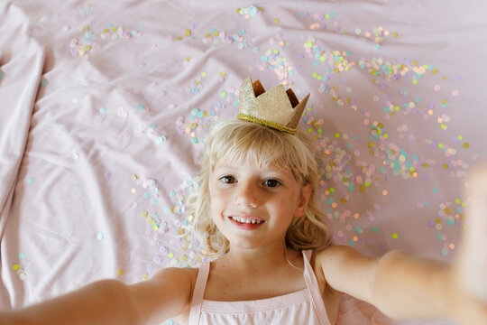 A birthday girl with confetti and a crown