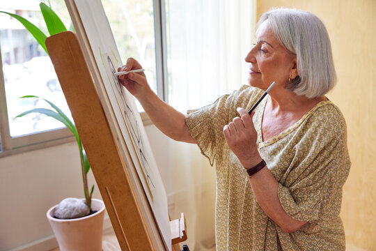 Female pensioner drawing portrait in daytime