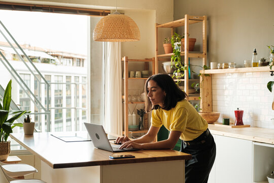 Woman using laptop in the kitchen
