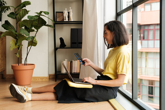 Woman using laptop and phone 