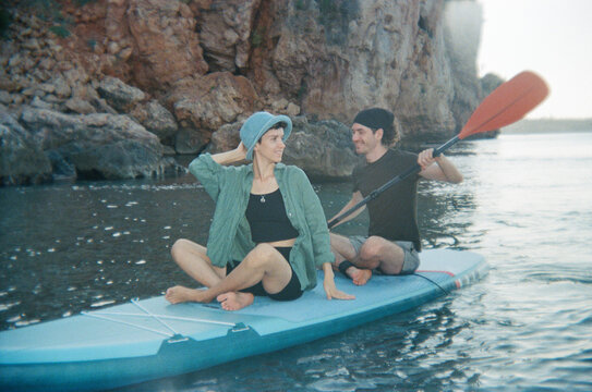 A man and a woman are swimming on a sap