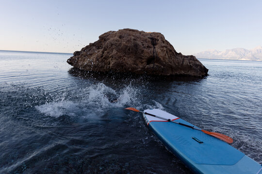 A man and a woman are swimming on a sup