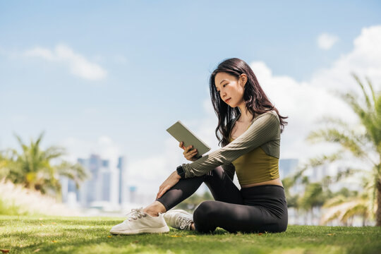 Girl reading e-book in the park
