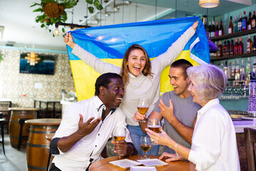 Happy fans celebrating the victory of Ukrainian team in the bar