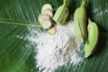 banana powder on wooden bowl and raw banana - banana fruit on leaf background, alternative flour, homemade green banana flour for herbal medicine nature herb - 546726491