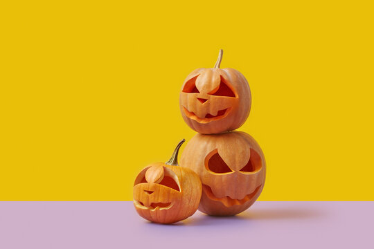 Three Halloween pumpkins on duotone background.