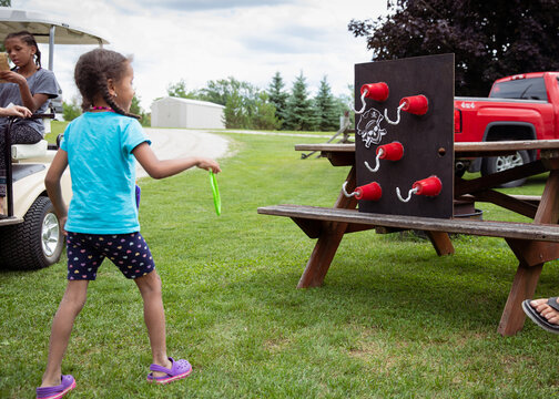 Child throwing rings at a target filled with pirate hand hooks