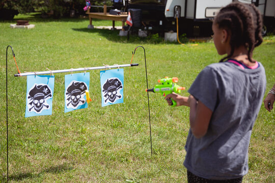 Child aiming at targets shaped like pirates