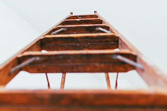 Front view of Antique wooden ladder in modern white brick warehouse
