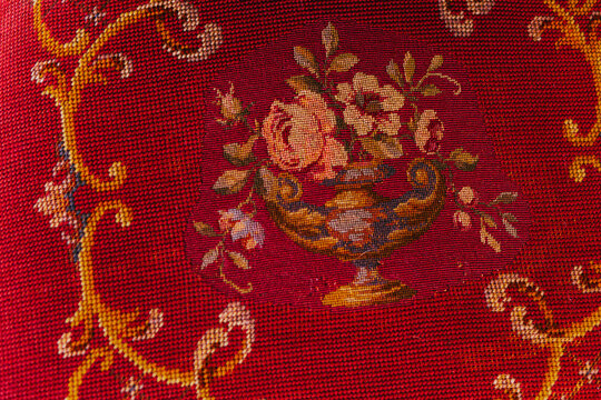 Vintage red embroidered chair seat with flowers in a vase