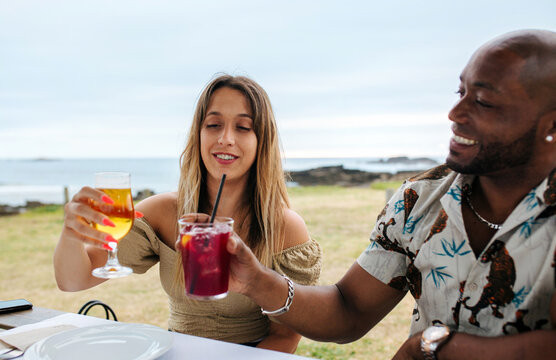 Cheerful diverse friends clinking glasses