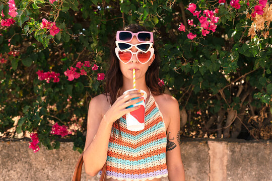 Woman drinking smoothie with sunglasses