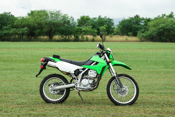 Naklejka premium Stylish cross motorcycle on green grass outdoors
