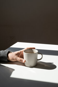 Image of Hand Holding Cup on Table