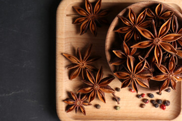 Obraz na płótnie Canvas Aromatic anise stars and spices on wooden board, top view