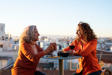 Happy senior women drinking wine on terrace