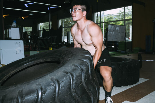 Men using big size tire in a gym