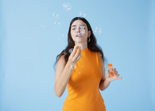Happy woman blowing soap bubbles
