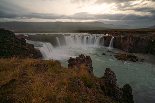 View of Godafoss Waterfall with a cloudy sky at sunset, Iceland