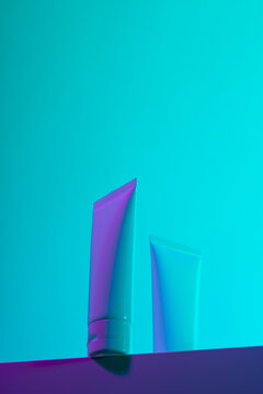 Set of violet hand-cream tubes on blue background in studio