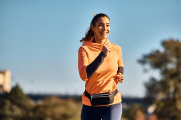 Motivated athletic woman enjoys while running outdoors.
