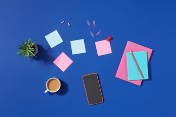 Top view of student table with headphone and stationery on blue