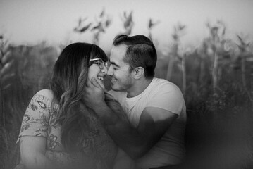 Black and white image of couple kissing in field