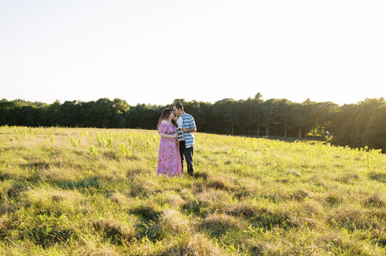 Romantic couple hugging in a field. they are expecting a child.
