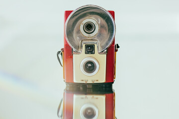 Vintage flash film camera arranged on a mirror with lens flare