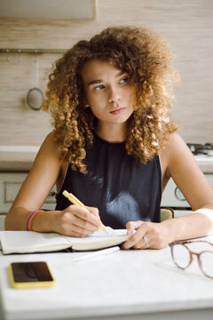 Young woman writes down thoughts with a personal diary