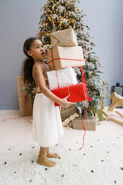 Happy black girl with Christmas boxes 