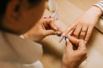 Female client getting nail extention by professional nail artist