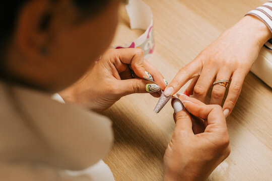 Female client getting nail extention by professional nail artist