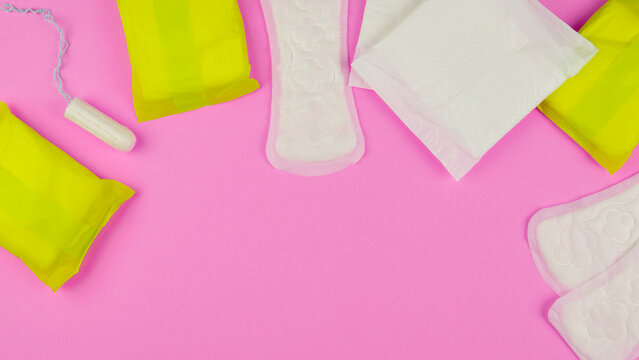 Hygiene products for women. Sanitary pads, tampon on a pink background. View from above