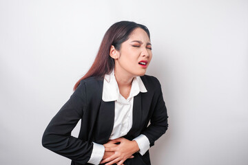 Fototapeta premium Upset young business woman suffering from stomachache, overworked at office. Gastritis or indigestion or constipation concept