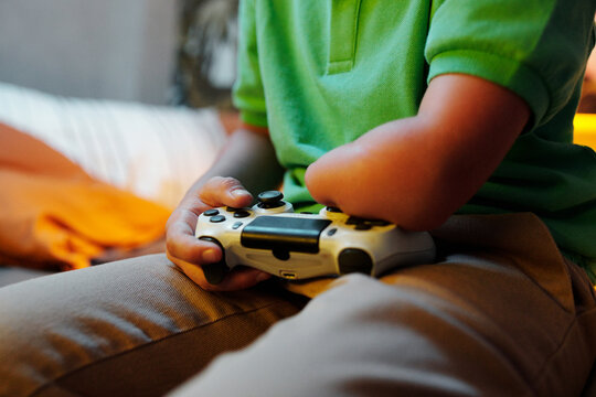 Unrecognizable Kid Playing Video Game in Evening