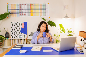 Female entrepreneur drinking coffee at office  