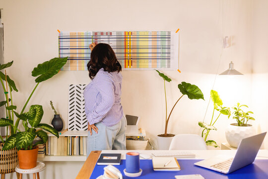 Woman writing in wall planner from the office