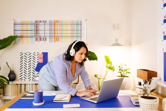 Latin woman with headset working in cool office