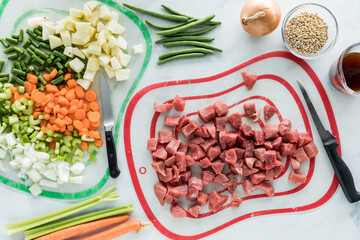 Freshly chopped vegetables and beef in preparation for beef and barley stew.