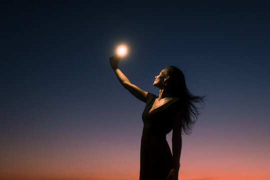 Smiling woman taking selfies during sunset