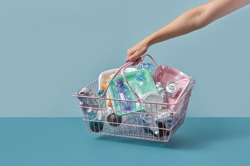 Various garbage inside wire basket in hand.