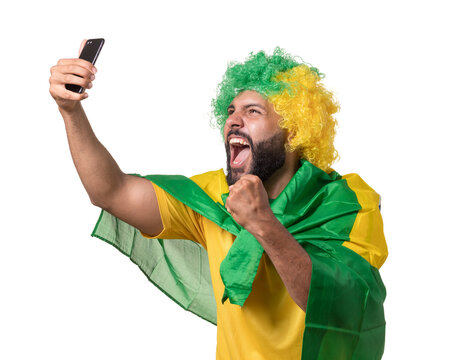 torcedor brasileiro feliz com peruca e bandeira do brasil com celular fazendo selfie 
