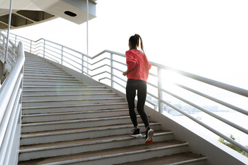 Healthy sporty woman running up stairs

