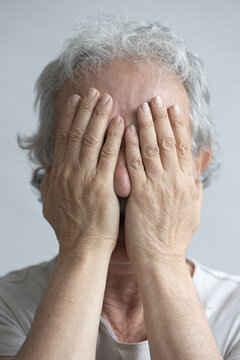 Middle-aged man covering his face