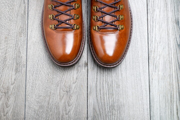 men's brown shoes on a gray, wooden background. View from above. space for text.